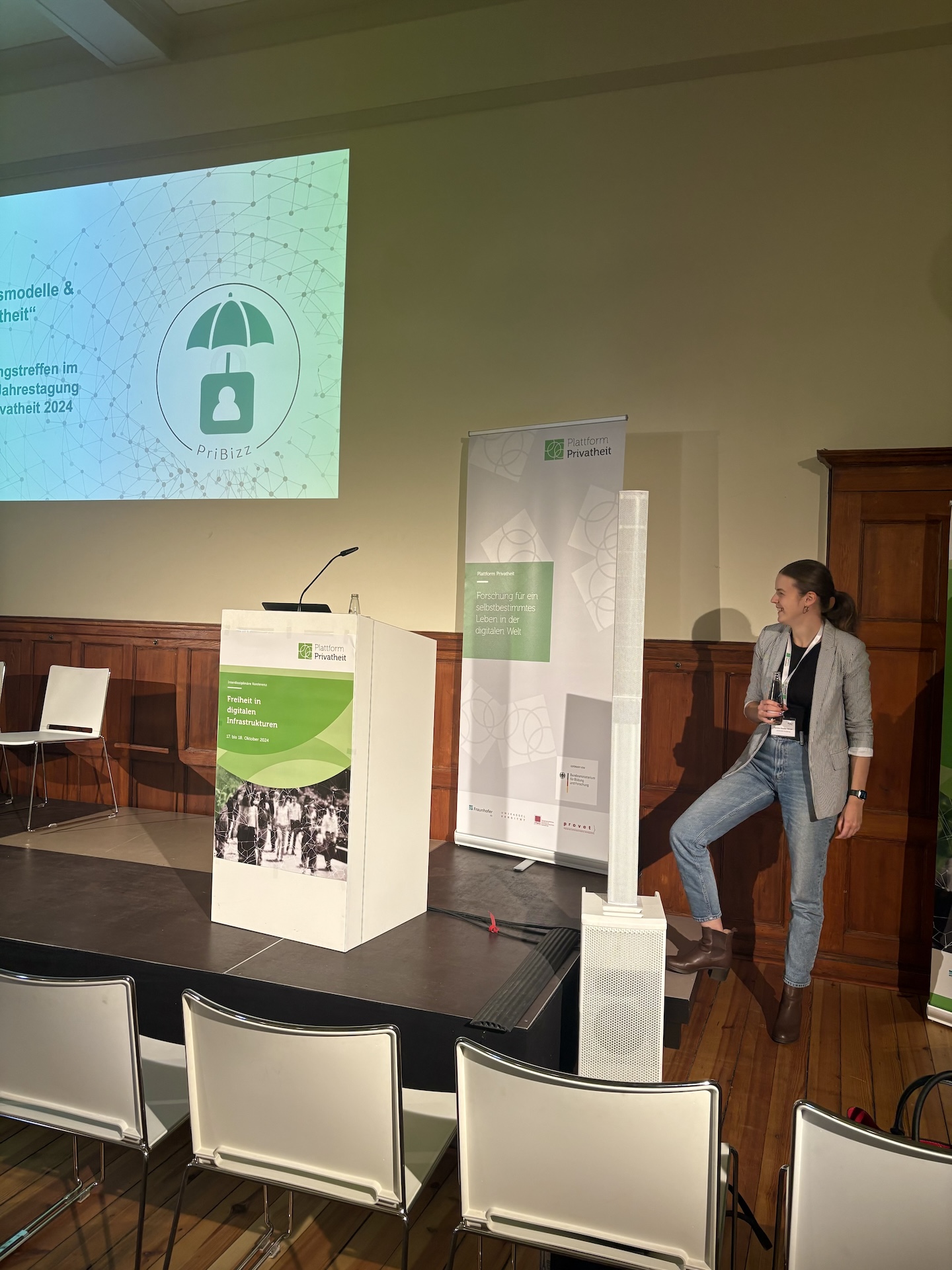 Eine Präsentation auf einer Bühne mit einer Frau, die auf einem Podium steht.